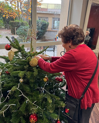 Résidente de La Constance décorant un sapin de Noël en 2024